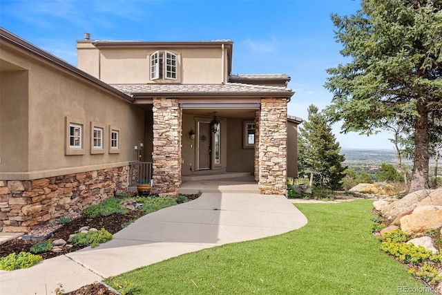 948 Manor Gate Pt, Colorado Springs, CO 80906 - property entrance with stone siding, stucco siding, and a lawn