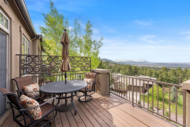 948 Manor Gate Pt, Colorado Springs, CO 80906 - wooden terrace with outdoor dining space and a mountain view