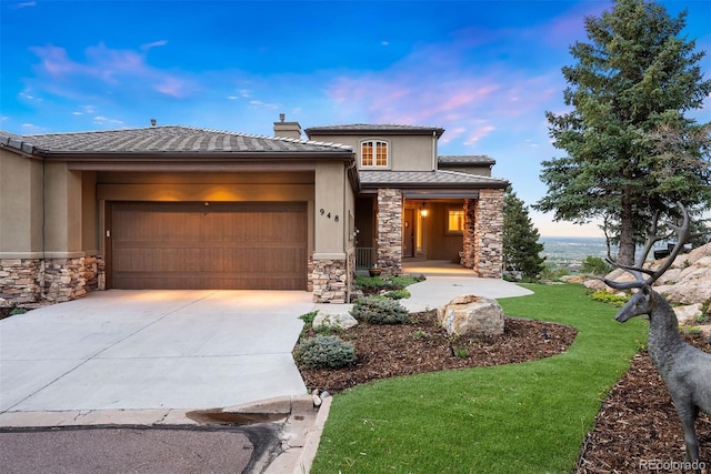 948 Manor Gate Pt, Colorado Springs, CO 80906 - prairie-style home featuring stone siding, driveway, an attached garage, stucco siding, and a chimney