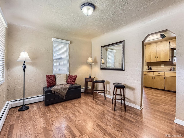 3265 S Ogden St, Englewood, CO 80113 - living area with a textured wall, a textured ceiling, light wood-style flooring, baseboards, and arched walkways