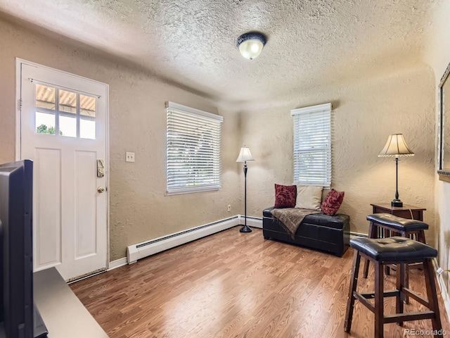 3265 S Ogden St, Englewood, CO 80113 - entryway featuring baseboard heating, a textured wall, a textured ceiling, wood finished floors, and baseboards
