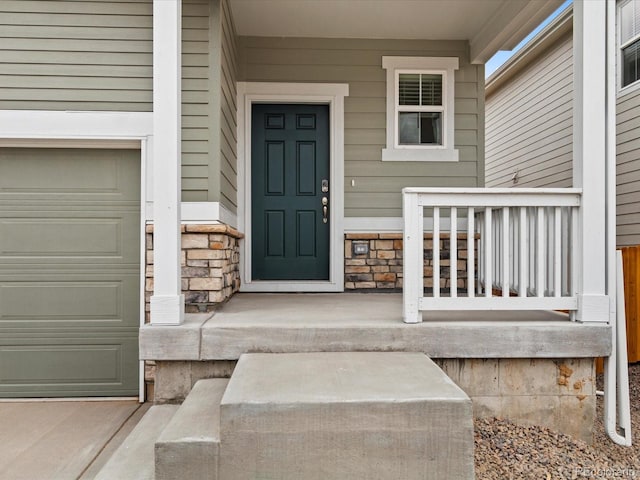 doorway to property with stone siding and a porch