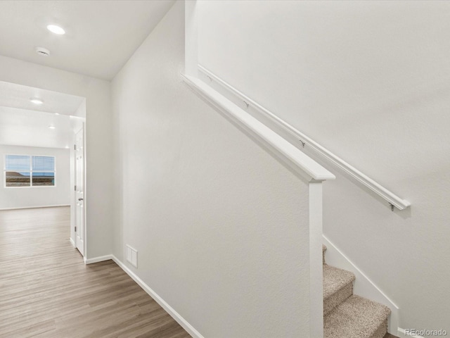 staircase with visible vents, baseboards, wood finished floors, and recessed lighting