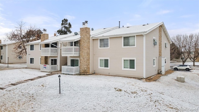 view of snow covered rear of property