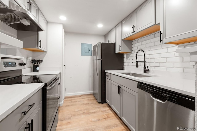 kitchen featuring gray cabinets, tasteful backsplash, sink, light hardwood / wood-style floors, and stainless steel appliances