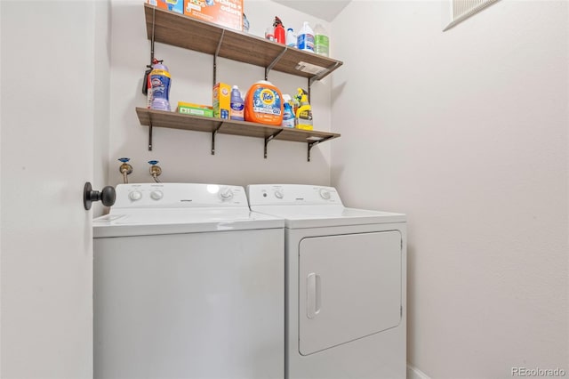 clothes washing area with washing machine and dryer