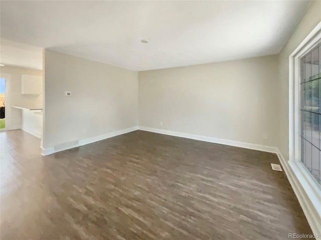 unfurnished room with dark wood-type flooring