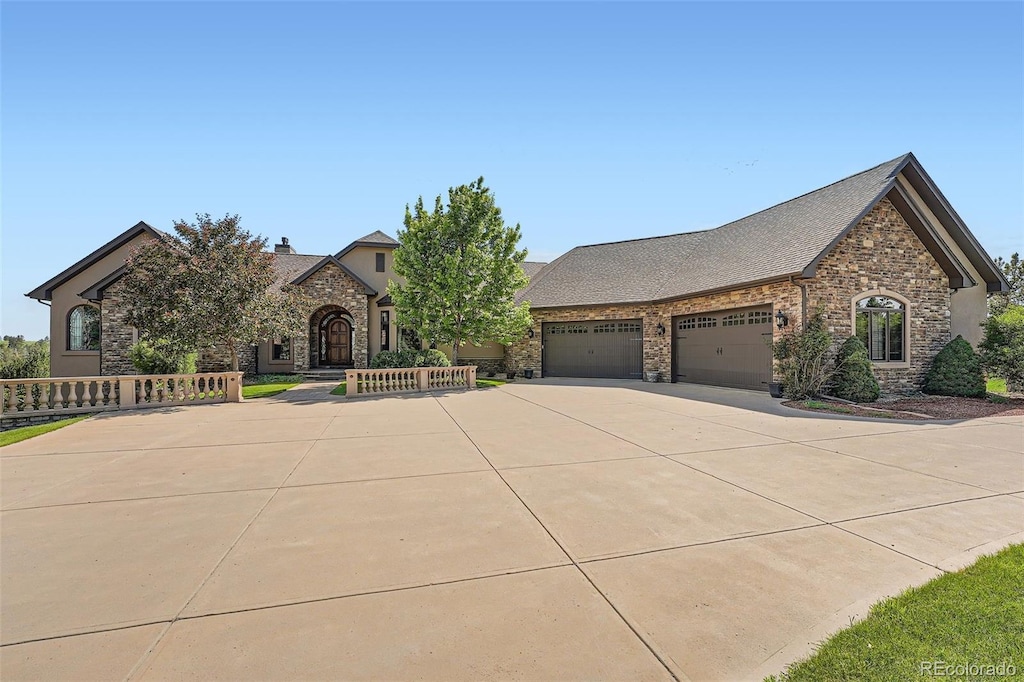 4725 Palmer Ridge Dr, Parker, CO 80134 - view of front facade with stone siding, an attached garage, concrete driveway, and a chimney