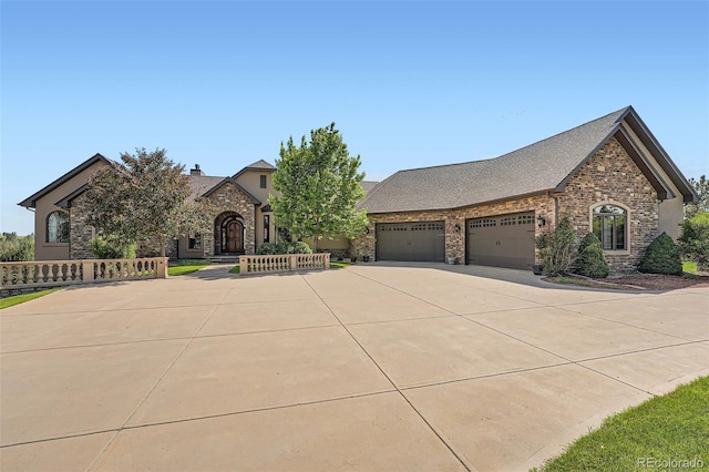 4725 Palmer Ridge Dr, Parker, CO 80134 - view of front facade with stone siding, an attached garage, concrete driveway, and a chimney