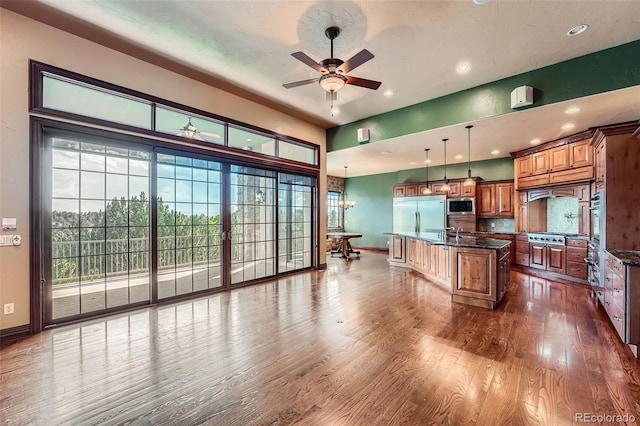 4725 Palmer Ridge Dr, Parker, CO 80134 - kitchen featuring built in appliances, brown cabinetry, recessed lighting, ceiling fan, and dark wood-style flooring