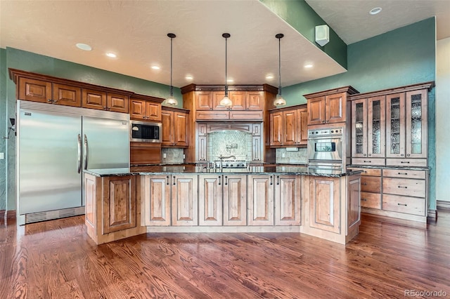 4725 Palmer Ridge Dr, Parker, CO 80134 - kitchen with built in appliances, dark wood-style floors, backsplash, a large island with sink, and recessed lighting