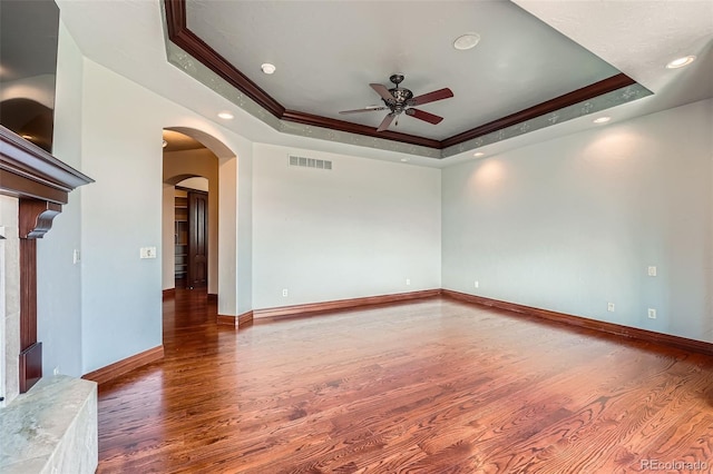 4725 Palmer Ridge Dr, Parker, CO 80134 - unfurnished room featuring a raised ceiling, wood finished floors, ceiling fan, ornamental molding, and arched walkways