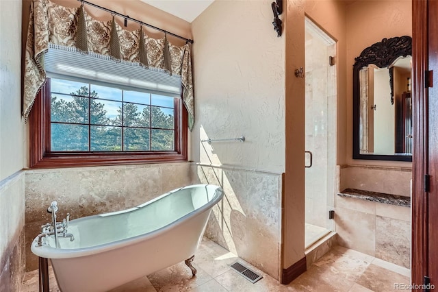 4725 Palmer Ridge Dr, Parker, CO 80134 - bathroom with healthy amount of natural light, a freestanding bath, a shower stall, tile walls, and wainscoting