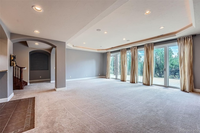 4725 Palmer Ridge Dr, Parker, CO 80134 - unfurnished living room with a raised ceiling, arched walkways, carpet flooring, recessed lighting, and stairs