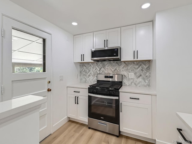 235 S Stuart St, Denver, CO 80219 - kitchen with stainless steel appliances, light wood-style floors, light countertops, white cabinets, and recessed lighting