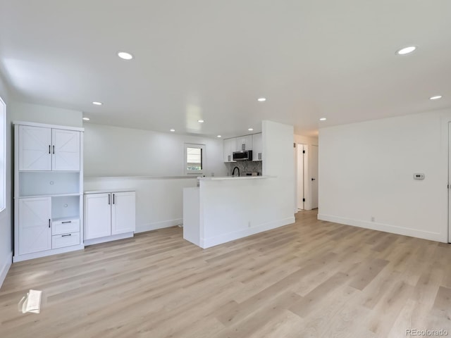 235 S Stuart St, Denver, CO 80219 - unfurnished living room with light wood-style floors and recessed lighting
