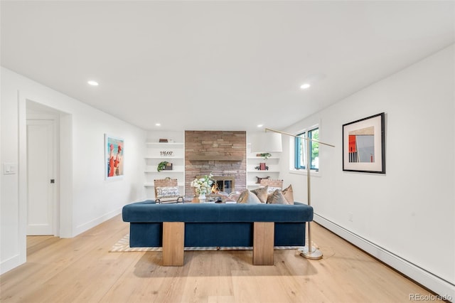 interior space featuring a fireplace, a baseboard radiator, recessed lighting, light wood-style floors, and baseboards