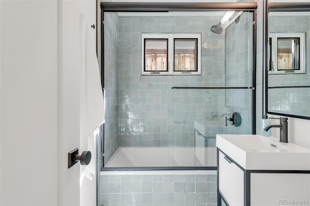 bathroom featuring tiled shower / bath combo and vanity