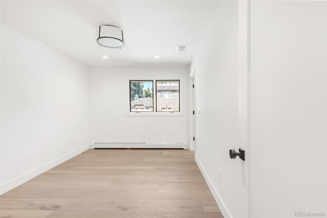 empty room featuring light wood-style flooring, recessed lighting, a baseboard heating unit, visible vents, and baseboards