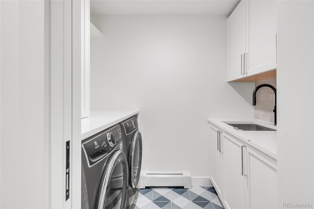 laundry area featuring cabinet space, baseboards, washer and clothes dryer, a baseboard heating unit, and a sink