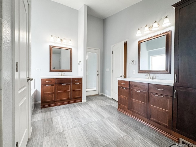 bathroom with a sink, baseboards, and two vanities