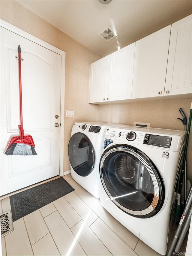 laundry room with light tile patterned flooring, visible vents, cabinet space, and independent washer and dryer