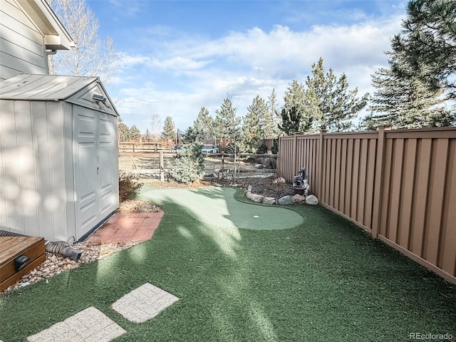 view of yard featuring a fenced backyard, a storage unit, and an outdoor structure