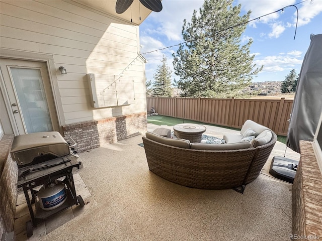 view of patio featuring outdoor lounge area, fence, and a grill