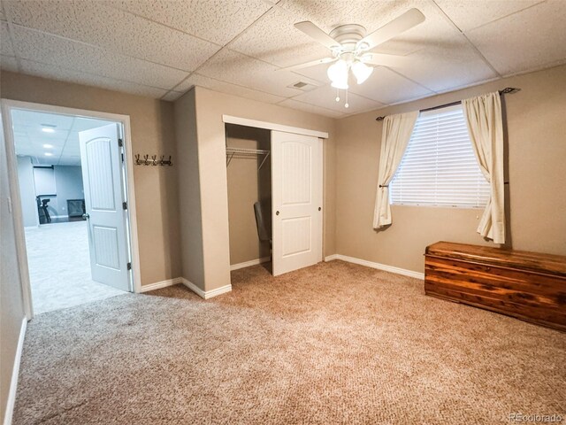 unfurnished bedroom featuring carpet, visible vents, baseboards, a paneled ceiling, and a closet