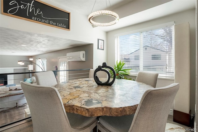 dining space with a textured ceiling and a wall mounted AC