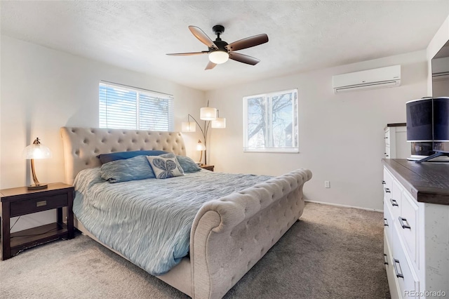 bedroom featuring baseboards, ceiling fan, a wall unit AC, light carpet, and a textured ceiling