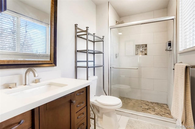 bathroom featuring toilet, a stall shower, vanity, and tile patterned flooring