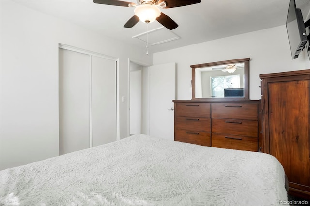 bedroom featuring a closet, attic access, and ceiling fan