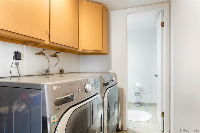 clothes washing area with light tile patterned flooring, cabinet space, and washer and dryer