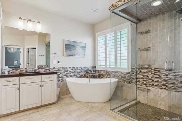 6927 Winter Ridge Pl, Castle Pines, CO 80108 - bathroom featuring a shower stall, tile patterned flooring, vanity, tile walls, and a freestanding tub