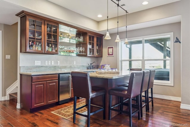 6927 Winter Ridge Pl, Castle Pines, CO 80108 - bar with indoor wet bar, hanging light fixtures, dark wood-type flooring, and baseboards