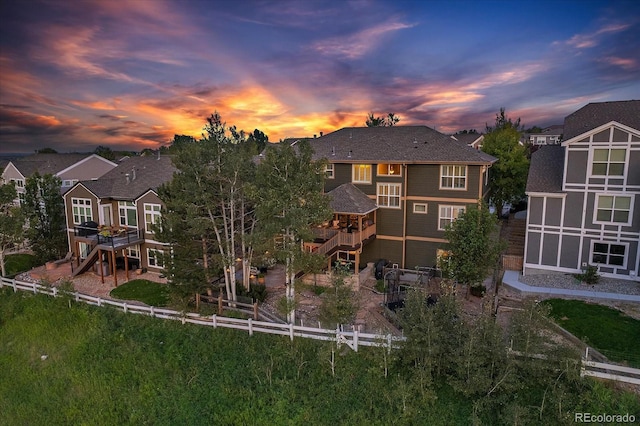 6927 Winter Ridge Pl, Castle Pines, CO 80108 - back of house at dusk featuring a fenced backyard and a residential view