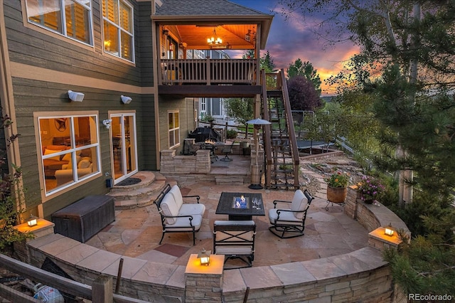 6927 Winter Ridge Pl, Castle Pines, CO 80108 - patio terrace at dusk featuring an outdoor fire pit and stairs