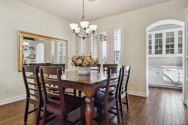 6927 Winter Ridge Pl, Castle Pines, CO 80108 - dining space with dark wood finished floors, baseboards, and an inviting chandelier