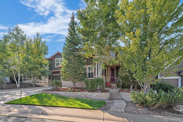 6927 Winter Ridge Pl, Castle Pines, CO 80108 - view of property hidden behind natural elements with concrete driveway and an attached garage