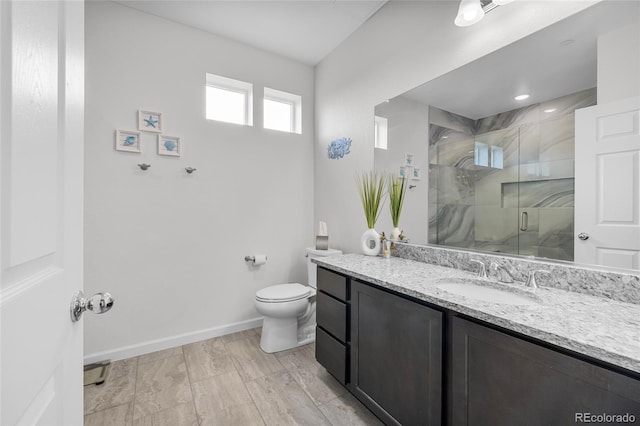 bathroom featuring toilet, an enclosed shower, and vanity