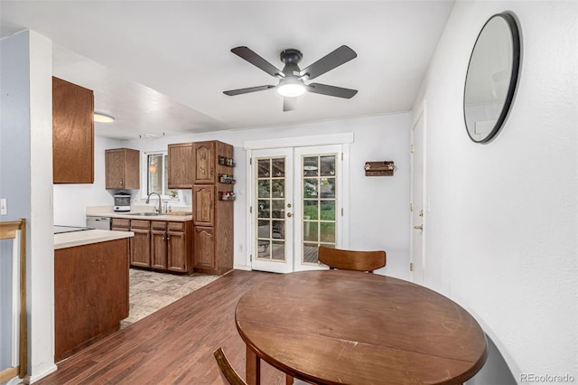 11886 Birch Dr, Thornton, CO 80233 - kitchen with french doors, light wood finished floors, light countertops, a ceiling fan, and brown cabinets