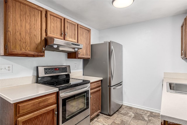 11886 Birch Dr, Thornton, CO 80233 - kitchen with appliances with stainless steel finishes, under cabinet range hood, baseboards, light countertops, and brown cabinets