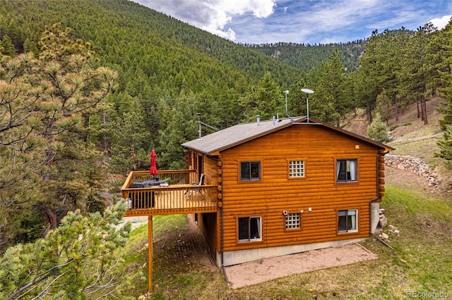 310 Wendelyn Way, Boulder, CO 80302 - rear view of house featuring a view of trees, a wooden deck, log exterior, and a carport