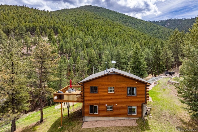 310 Wendelyn Way, Boulder, CO 80302 - rear view of property featuring a wooded view, log exterior, a deck with mountain view, and a lawn
