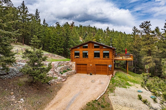310 Wendelyn Way, Boulder, CO 80302 - view of front of house with driveway, log siding, a forest view, and an attached garage