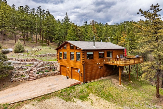 310 Wendelyn Way, Boulder, CO 80302 - rear view of house with driveway, a view of trees, a wooden deck, log siding, and a garage
