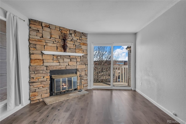 4460 S Pitkin St Unit 120, Aurora, CO 80015 - unfurnished living room with wood finished floors, baseboards, a fireplace, and a textured wall