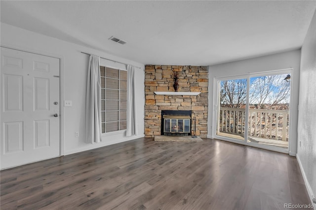 4460 S Pitkin St Unit 120, Aurora, CO 80015 - unfurnished living room with wood finished floors, a stone fireplace, and baseboards