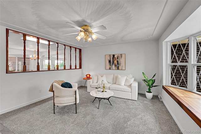 living room featuring carpet, baseboards, a ceiling fan, and a healthy amount of sunlight